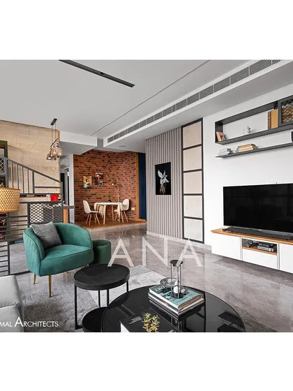 A view across the living room of Apartment 704, highlighting the mix of textures. The design balances minimal furniture with feature elements like the brick wall and a stone-clad bar area.