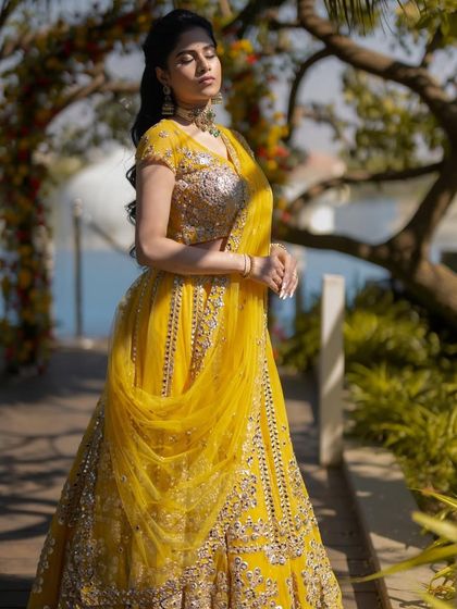 A stunning full-length shot. The vibrant yellow outfit and the radiant, sun-kissed makeup create a look that is pure sunshine.