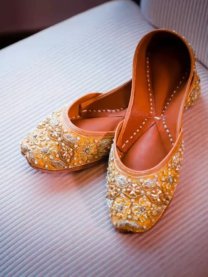 A close-up shot of the bride's beautiful wedding shoes (juttis). Capturing these details is part of telling the complete story of your wedding day style.