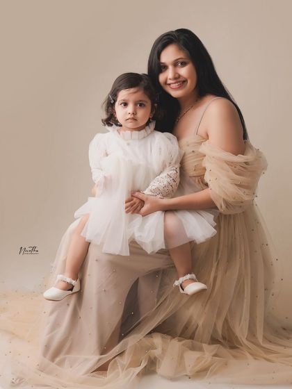 A beautiful portrait of a mother and daughter in elegant dresses.