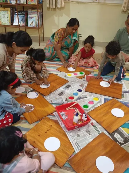 Children are deep in concentration during a dot painting activity. This craft helps develop fine motor skills and color recognition.