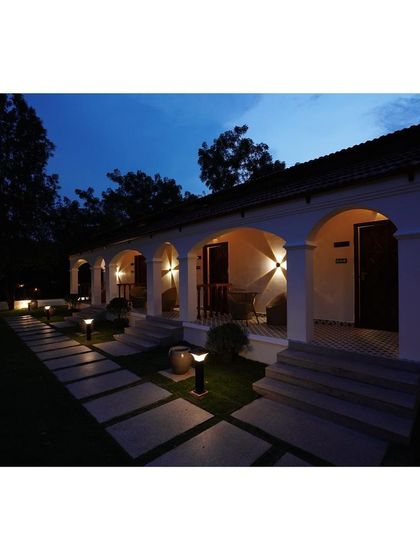 Another night view of the villa, focusing on the balanced and symmetrical lighting design. The uplights on the pillars and path markers ensure the property is both safe and aesthetically pleasing after dark.