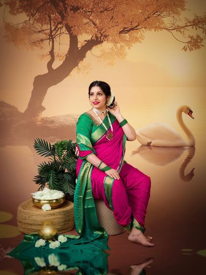 A fine art portrait with a painterly background. The mother-to-be, in her traditional attire, looks serene and majestic against the sunset lake scene.