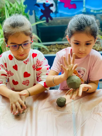 Teamwork in action! These girls are helping each other perfect the shape of their clay creations during our festive Ganesha art workshop.