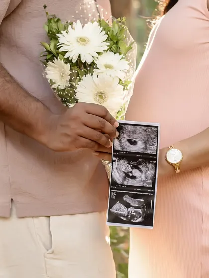 Sharing your first family photo. Holding up the sonogram picture during your outdoor shoot is a sweet way to include your little one in the portraits.