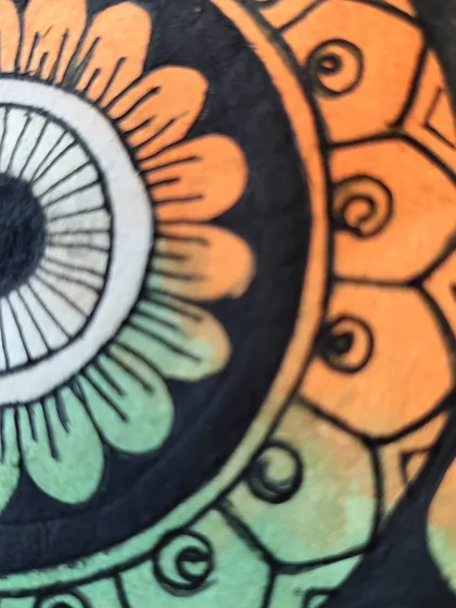 Another detail shot of the saffron and green sections of the mandala.