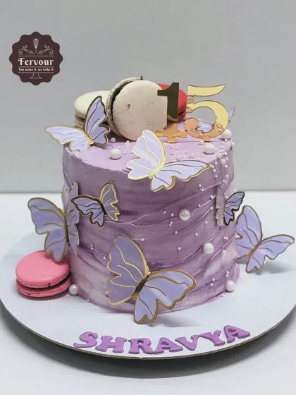 A lovely lavender-coloured chocolate Nutella cake decorated with butterflies and macarons. The watercolour effect on the frosting gives it a soft, dreamy look.