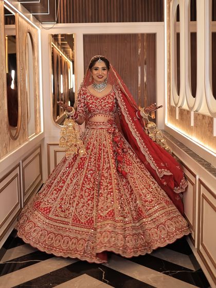 A full-length shot of my bride in her magnificent red lehenga. The makeup is designed to complement the grandeur of the outfit and the venue.