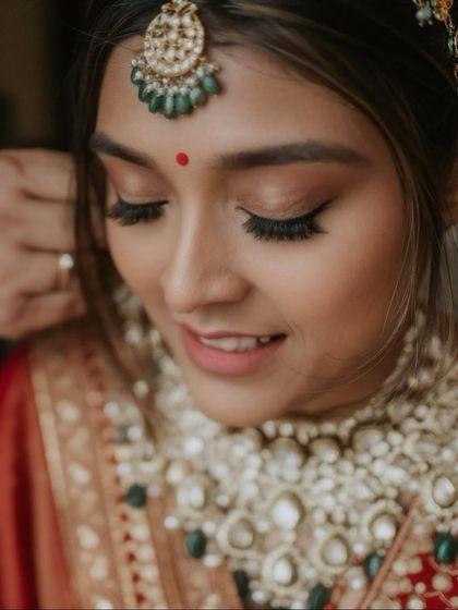 A moment of quiet reflection. This shot highlights the delicate eye makeup, with soft brown tones and full lashes, creating a look that is both gentle and captivating.