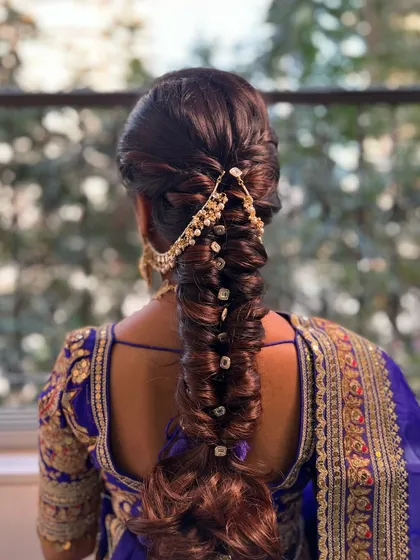 A detailed look at a textured fishtail braid, perfect for a sangeet or mehendi. I wove in a traditional gold accessory to complement the client's royal blue saree, making the whole look cohesive.