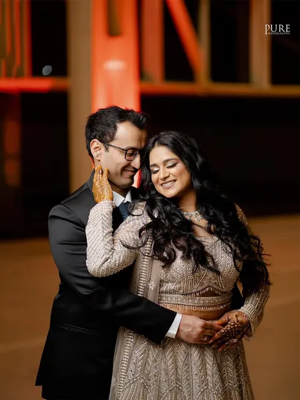 A happy and intimate embrace. This photo captures the couple's joy and affection during their cocktail party celebration.