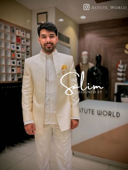 A client looking pleased in a custom-fitted ivory Jodhpuri suit. The jacket features a subtle self-striped texture and is paired with a matching inner kurta and a pop of color from the yellow pocket square.