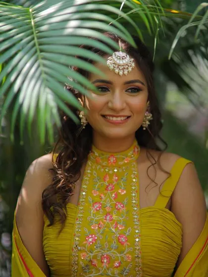 A playful shot of the mehendi bride, peeking through a palm leaf.