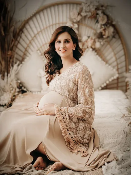 A smiling portrait from one of our boho-themed setups. The rattan headboard, pampas grass, and warm tones create a relaxed, earthy, and stylish atmosphere.