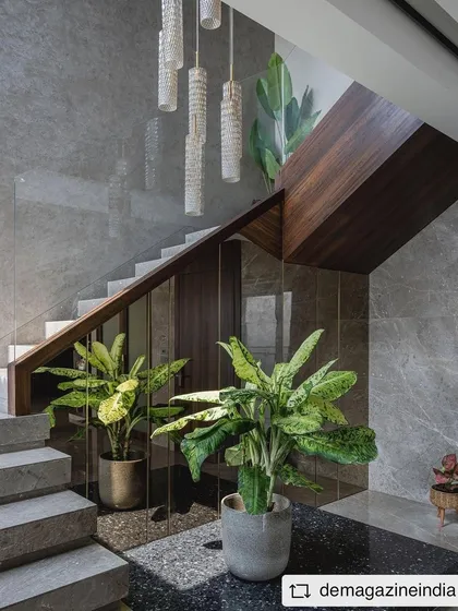 A closer look at the staircase in 'Aria Residence', showing the beautiful texture of the grey marble and the cluster of pendant lights that illuminate the stairwell.