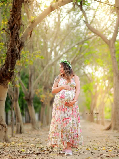 A solo portrait of the mother-to-be in a floral dress, surrounded by the beauty of the park. Her gentle smile radiates happiness.