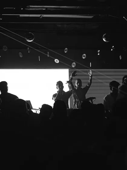 A black and white shot capturing the silhouettes of the crowd and the DJs at MOBE 26.