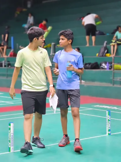 A moment of discussion and camaraderie between two young players during a break in their training session.