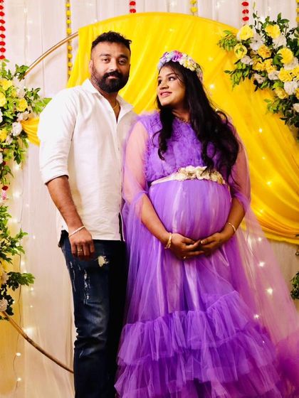 This lavender ruffled gown, complete with a floral crown, is a sweet and whimsical choice for a baby shower or maternity photoshoot.