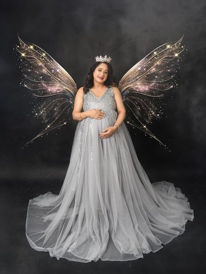 A fairytale moment with sparkling wings. This creative edit transforms the mom-to-be into a beautiful fairy queen in her shimmering silver gown.
