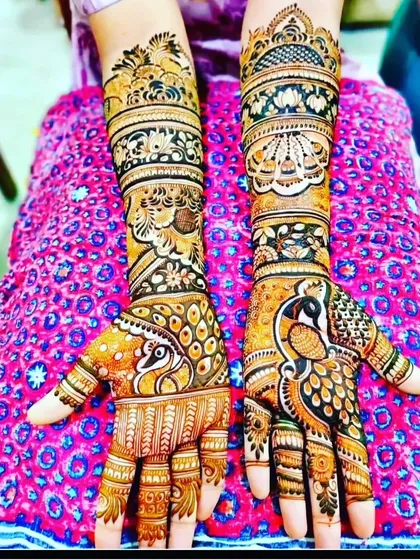 This design is dominated by large, beautiful peacock figures on the palms. The arms are filled with traditional floral and paisley patterns.