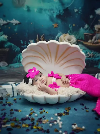 A precious pearl in a shell. This little mermaid is resting in a large seashell prop as part of our underwater fantasy theme for newborns.