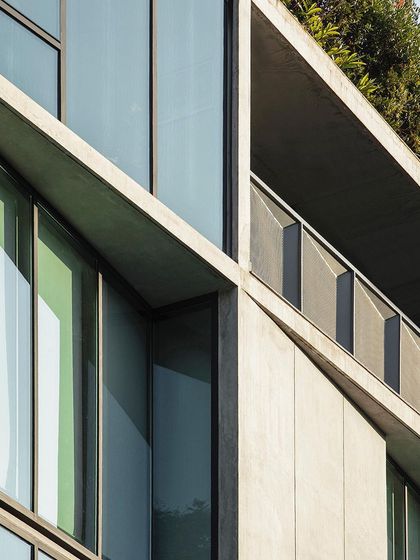 The angled concrete planes and deep-set windows of our studio facade create a play of light and shadow. These details are not just aesthetic but also functional, helping to control solar gain while framing views of the neighborhood.