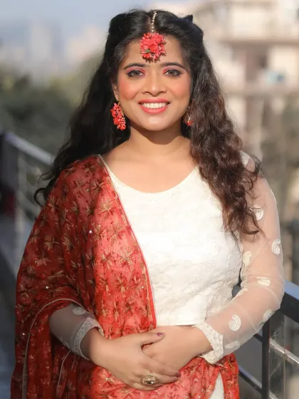 A fresh and radiant Haldi ceremony look. The makeup is light and dewy to give a natural glow, complemented by beautiful floral jewelry and a bright, happy smile.