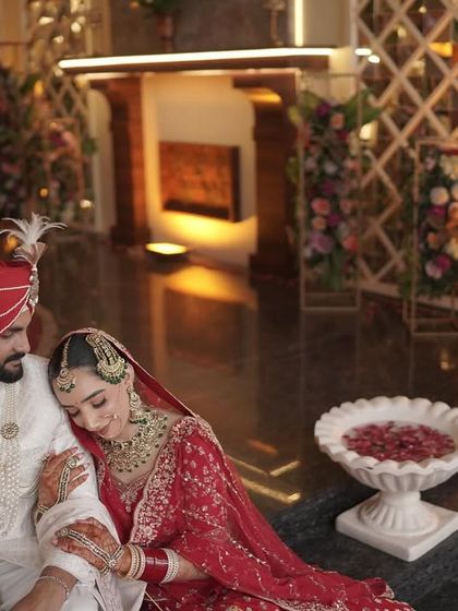 A quiet moment between the bride and groom. Her traditional red attire is paired with classic makeup that looks beautiful and romantic.