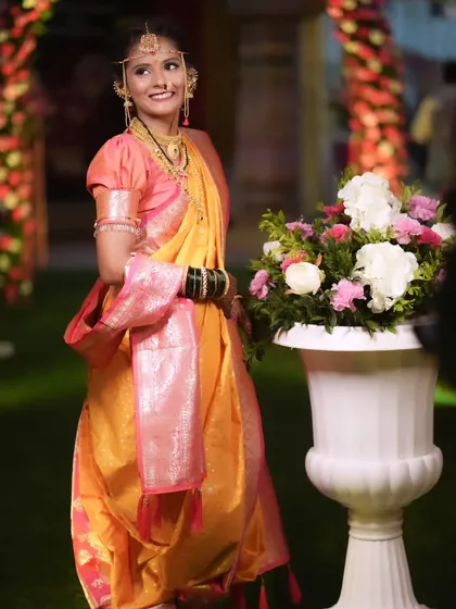 The bride posing gracefully, showcasing her complete look from the elegant puff-sleeved blouse to the traditional jewelry.