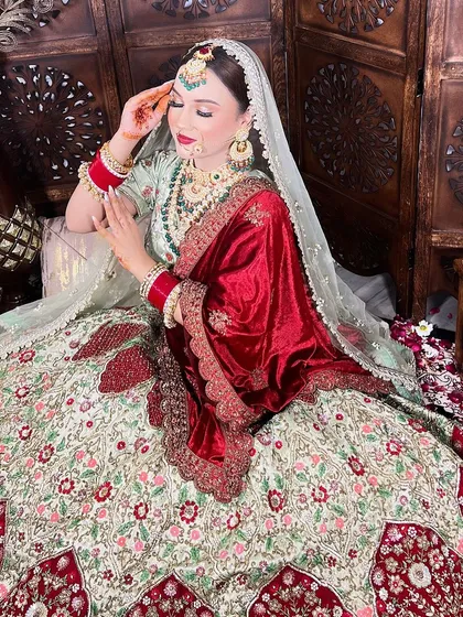 This bride looks like royalty in our intricately embroidered lehenga with a contrasting red velvet dupatta. This is a perfect example of owning a high-end look for less.
