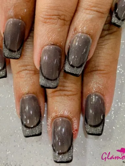 A moody and glamorous French manicure. We used a glossy, deep brown base and added a sparkling silver glitter French tip, outlined with a thin black line for a sharp, sophisticated finish.