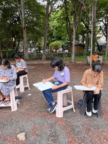 Our students set up in a local park, fully concentrated on their sketchpads. These sessions are designed to build their confidence in drawing in a public setting.