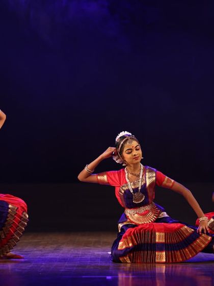 A group of three students in a graceful, seated posture. This highlights their control and ability to hold complex poses with poise.