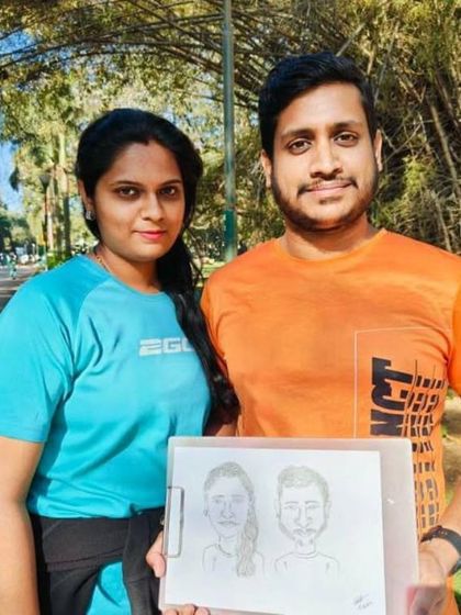 A close up of the couple with their finished caricature. I focus on getting a great likeness while keeping it fun and lighthearted.