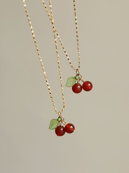 A detailed shot of the cherry charm necklaces. These are made with high-quality materials to ensure they last and bring a smile to your face.