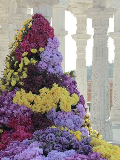 A detailed shot of one of the cascading floral arrangements, highlighting the beautiful blend of purple, yellow, and magenta blooms.
