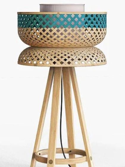 A unique floor lamp design featuring a woven bamboo basket shade set atop a wooden tripod base. This piece combines functionality with a modern, eco-friendly aesthetic, perfect for a living room corner or study.