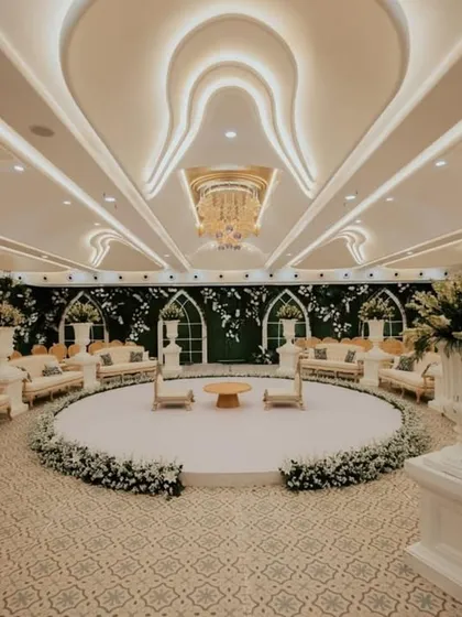I transformed this indoor banquet hall into a serene, white-themed paradise for an engagement ceremony. The circular stage, surrounded by lush floral arrangements and elegant white lounge seating, created a sophisticated and intimate setting for the couple.
