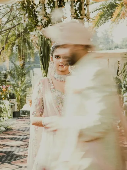 An artistic motion-blur shot capturing the groom walking past the bride, creating a dynamic and modern feel.