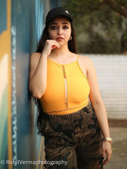 A softer portrait from the same series, with the model wearing a cap for a more casual vibe.