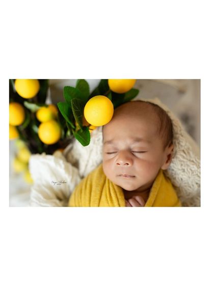 Another angle of our lemon-themed setup, showing the baby nestled amongst the bright yellow fruit. The textures and colors come together to create a beautiful image.