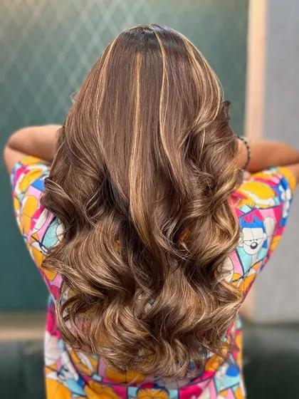 A full view from the back, showing off the beautiful blend of honey and brown tones. The waves add texture and volume, making the hair look full and healthy.