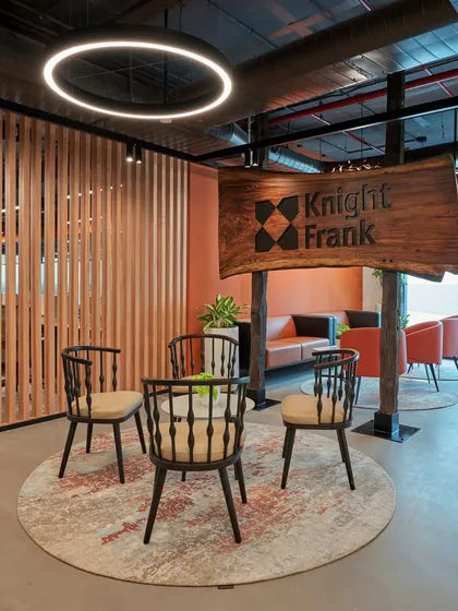 A rustic yet refined reception area for Knight Frank. We used a live-edge wood slab for the signage, complemented by modern Windsor-style chairs and warm, layered lighting.
