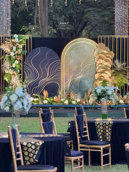 A stylish photo booth or selfie point for the Sangeet, with modern arched backdrops, gold-line detailing, and pampas grass arrangements.