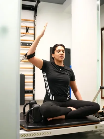 A client embraces the mindful practice of Pilates, connecting with her body through controlled movement. This exercise helps build shoulder stability and core control.
