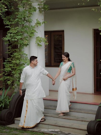 A classic portrait of the couple walking down the steps of a traditional house, hand in hand.