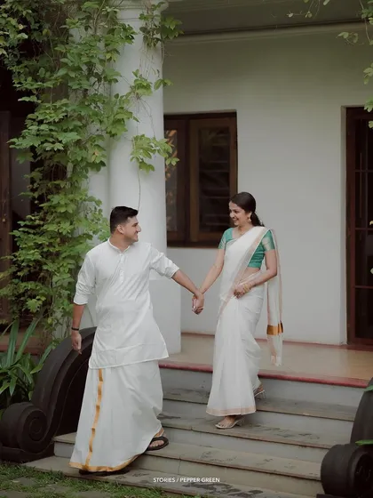 A classic portrait of the couple walking down the steps of a traditional house, hand in hand.