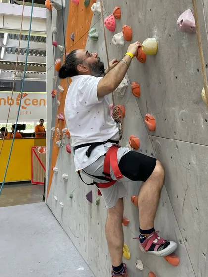 A beginner gets ready to tackle a route. With a harness on and a belayer ready, you're all set to start your vertical journey.