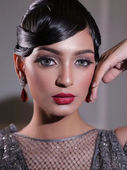 Unleashing the glam with bold eyes and glowing skin. This look, with its vintage-inspired hair and dramatic red lip, is all about confidence, elegance, and unstoppable beauty.